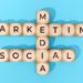 imagem com vários cubos pequenos com letras que juntos formam 3 palavras: marketing social e media