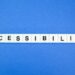 Letras num fundo azul com a palavra acessibilidade em inglês representando a acessibilidade audiovisual