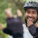 um homem de bicicleta conversando em língua de sinais com outra pessoa representando o tema da comunicacao inclusiva